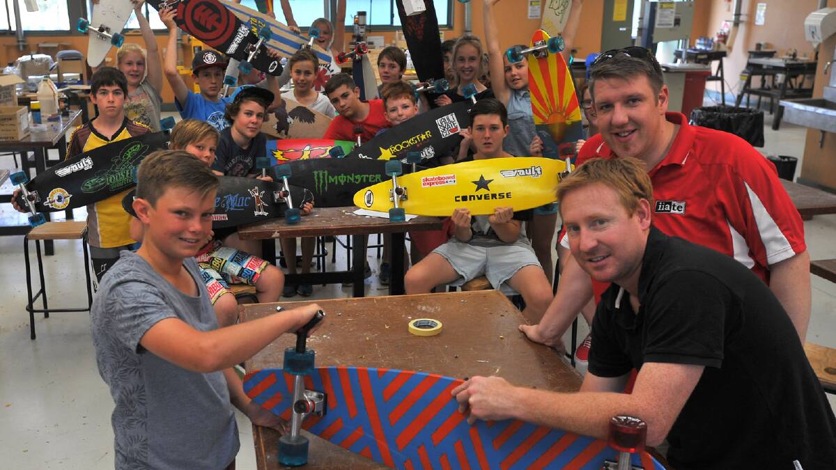 Luke Maslin, 13, with TAS teachers Connor Macmurray and Clint Campbell with the rest of the class showing off their longboards in the background. Picture: Addison Hamilton