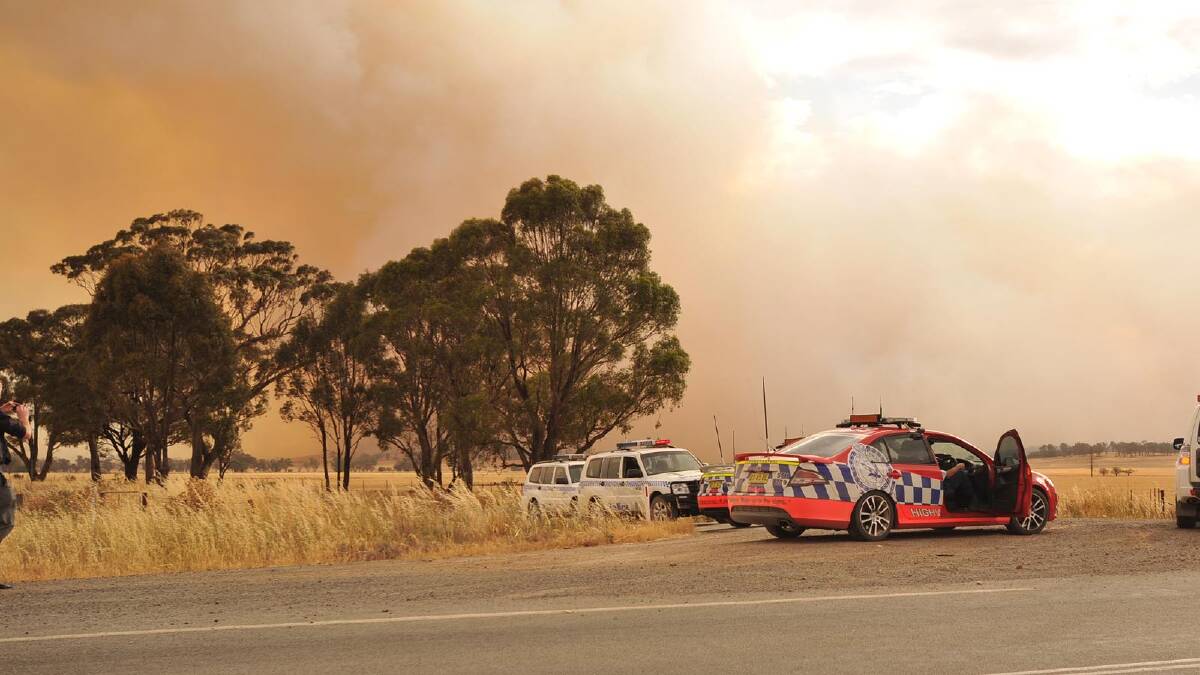 Police blocking the roads as the blaze approaches the township of Stockinbingal. Picture: Michael Frogley