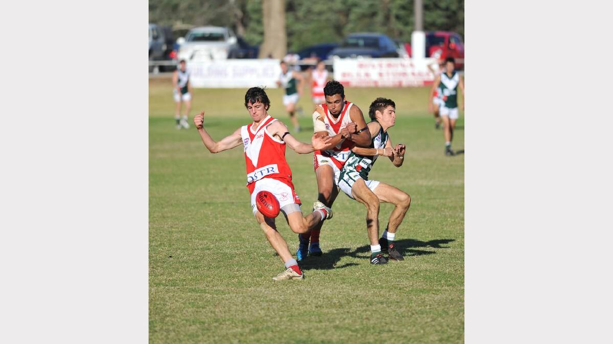 Collinguille's Daniel Kennedy kicks while teammate Chris Gordon bumps off Coolamon's Mark Crawford. Picture: Alastair Brook
