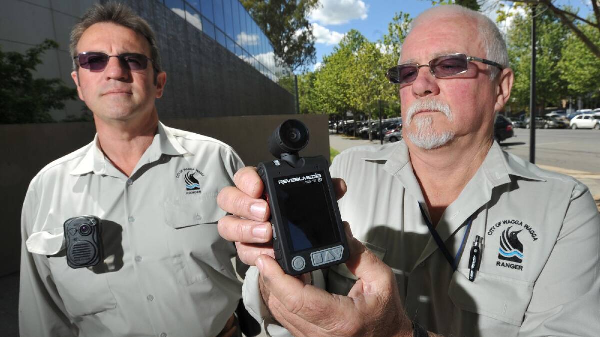 Wagga city council rangers Kevin Nisbet (left) and Jeff Todd show off the latest addition to their everyday work attire – personal recording devices which capture audio and video, aimed to protect staff who work on their own. Picture: Les Smith