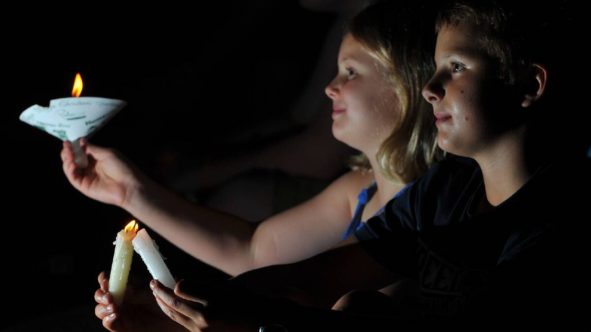 Dion Wilson, 9, and Bailey Wilson, 13, share the candlelight at the Wagga Christmas Spectacular. Picture: Addison Hamilton