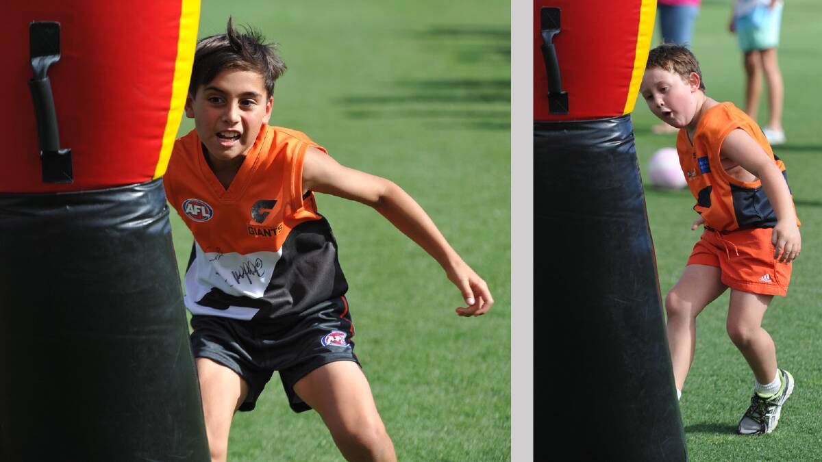 Harry Wichman (left), 10, Wagga, and Ned Buchanan, 6, Wagga practice their tackling skills. Picture: Les Smith