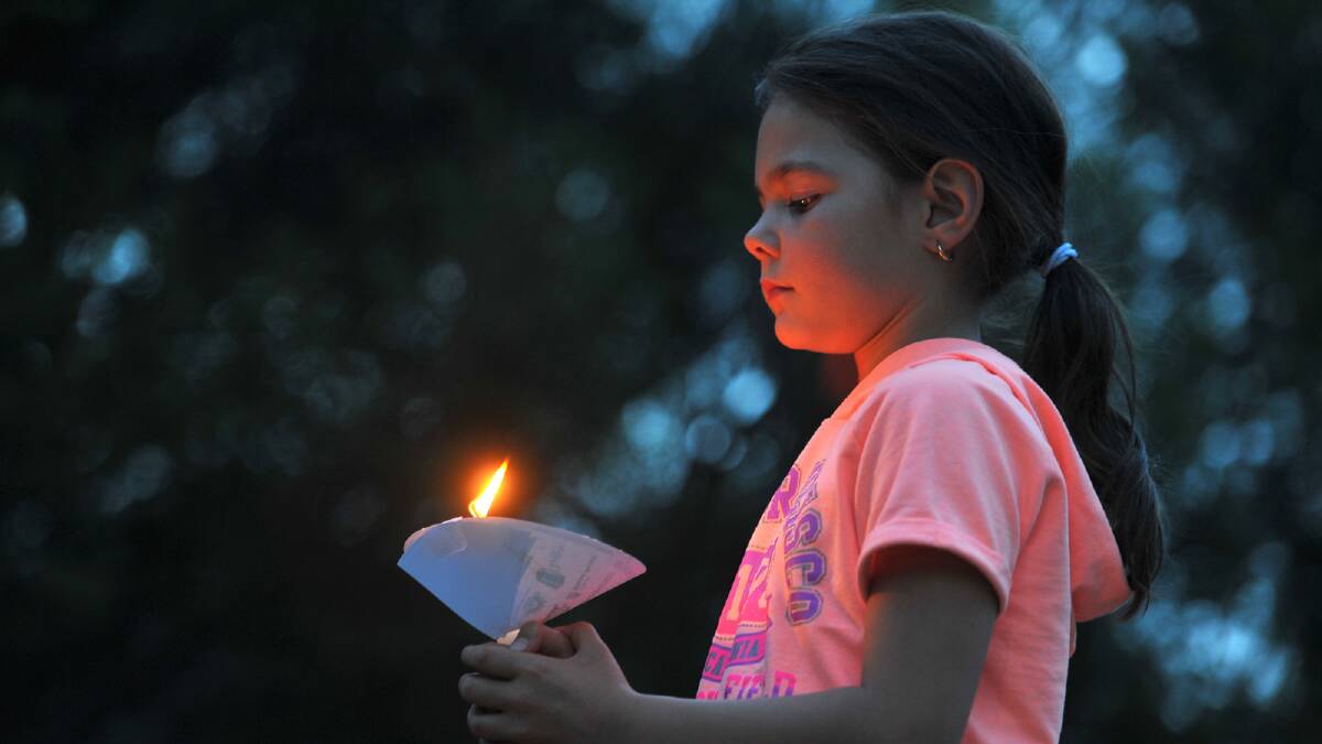 Veronica Charlton, 9, keeps an keen eye on her candle during the Wagga Christmas Spectacular. Picture: Addison Hamilton