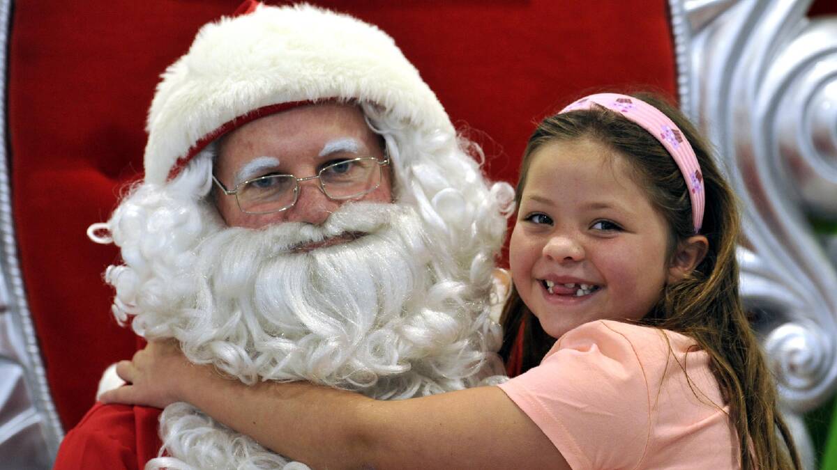 Alice Britton, 6, give her Christmas wish to Santa at the Marketplace. Picture: Les Smith