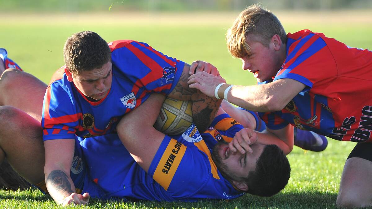 Junee's Toby Key is tackled by Kangaroos players Steve Morris and Hayden Jolliffe. Picture: Addison Hamilton