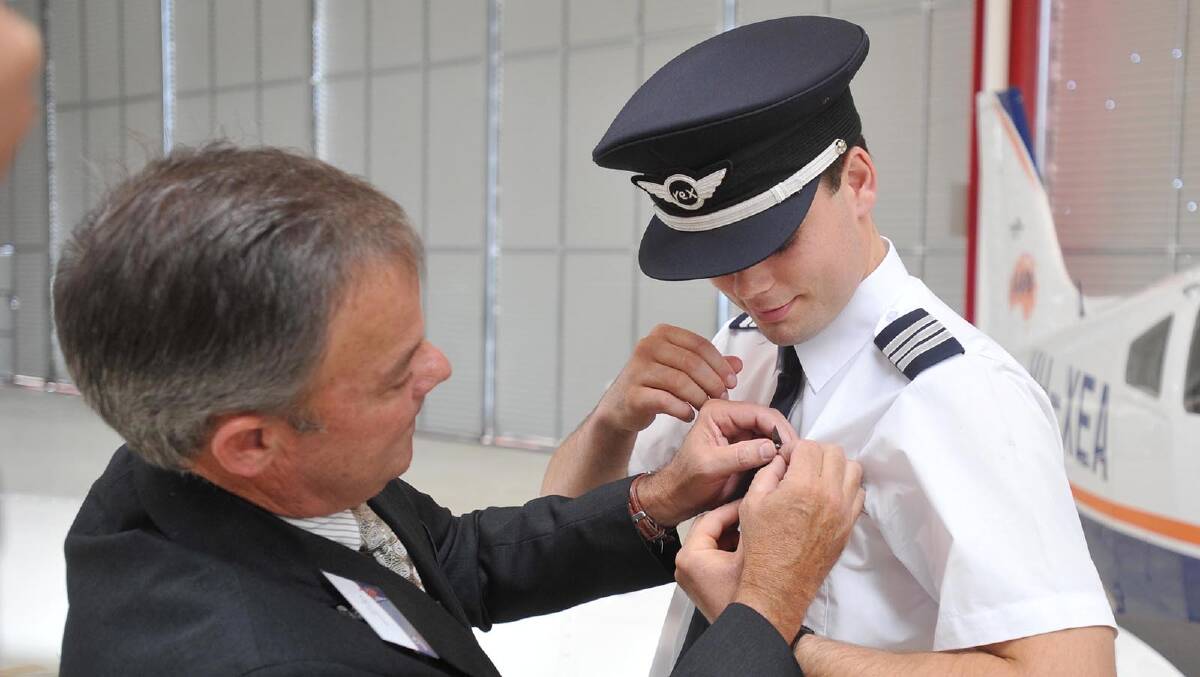 Alexander Preddey having his pilot's wings pinned on by father Mark. Picture: Alastair Brook
