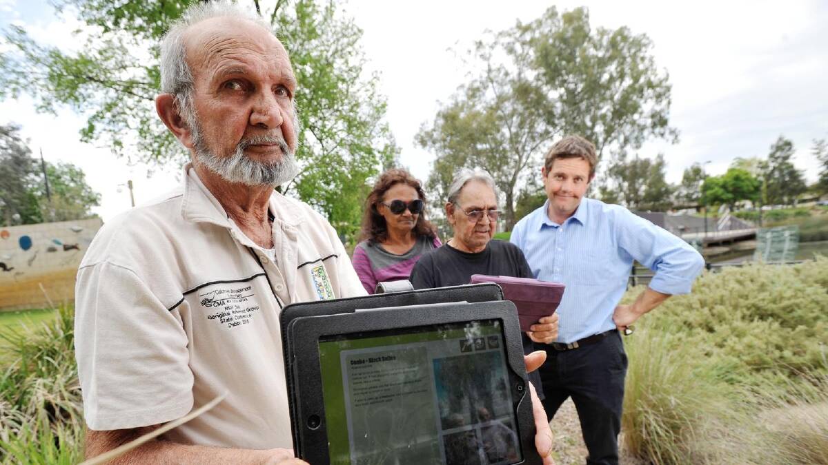 Jim Ingram from the Murrumbidgee traditional custodians group holds an iPad with the ebook on bush flora launch at the Wollundry Lagoon, with Ramsay Freeman from the Murrumbidgee traditional custodians group), authors Alice Williams and Tim Sides. Picture: Alastair Brook