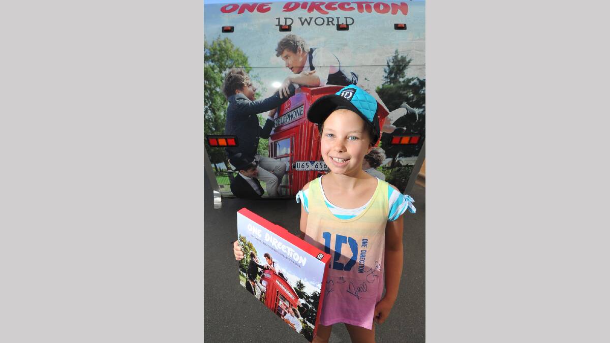 Madison Crawford, 8, with her new merchandise from the travelling One Direction merchandise truck. Picture: Addison Hamilton