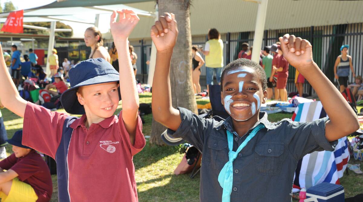 Joshua Ryan, 13, and Samuel Rajabu, 12, cheering on classmates at the Wagga Christian College swimming carnival.