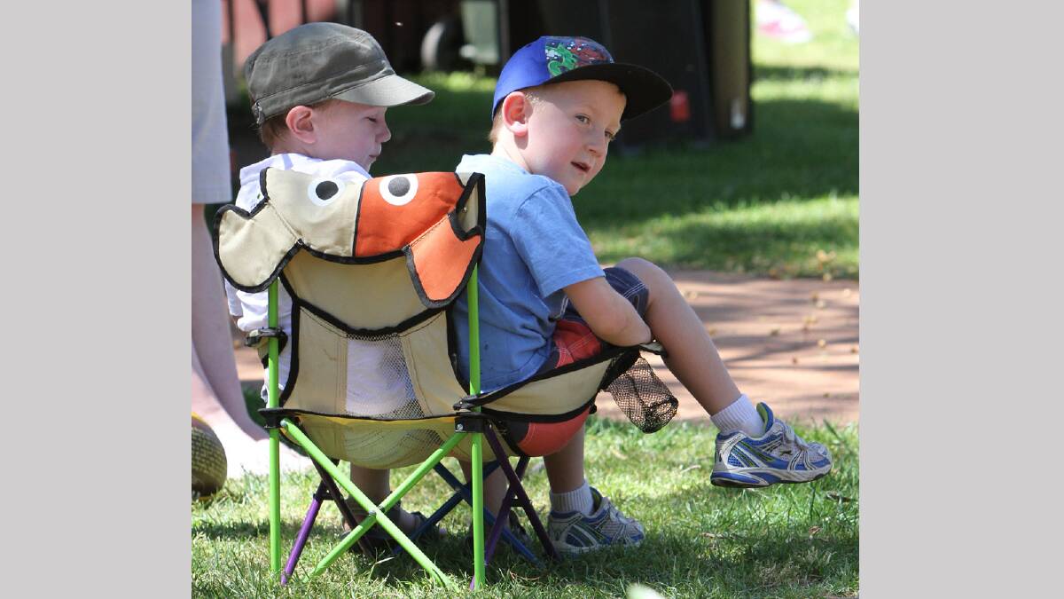 Nate Breust, 3,and Deklan Moore, 5, share a chair at the Parade of Premiers. Picture: Les Smith