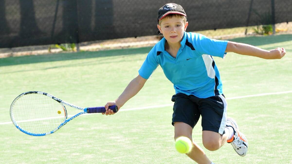 Henry Kennedy, 9, scrambles to reach the ball in junior tennis. Picture: Michael Frogley
