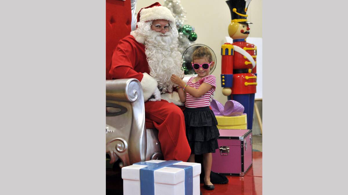 Eliza Murphy, 5, gets a feel for Santa's beard. Picture: Les Smith