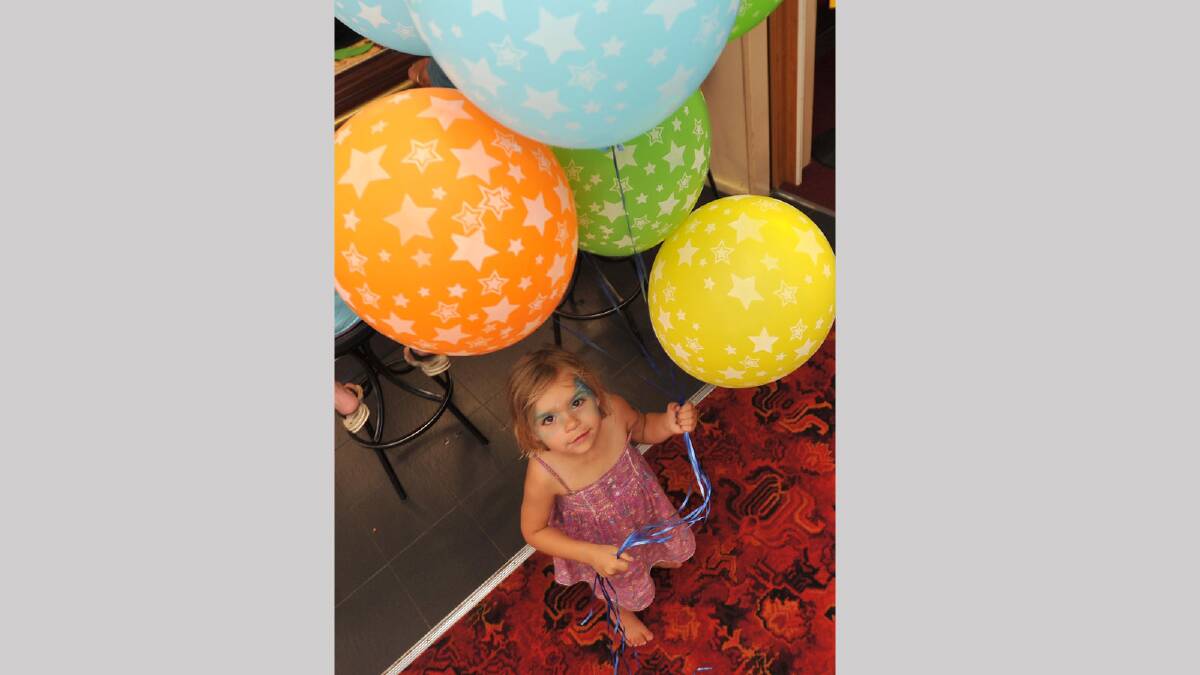 Hope Hardman, 3, plays with some balloons at the fundraiser for Kellie Wall at the Ganmain Bowling Club. Picture: Michael Frogley 