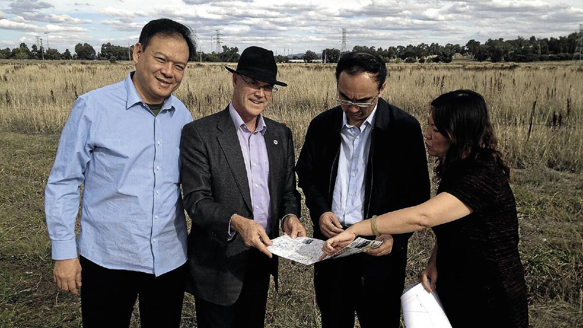 FLYING VISIT: Delegates from the Wuai Trade Group Humphrey Xu (left), party secretary Wang Jian (second from right) and Lydia Zhang (right) look over plans for the $400 million trade centre development with Wagga City Council general manager Phil Pinyon.