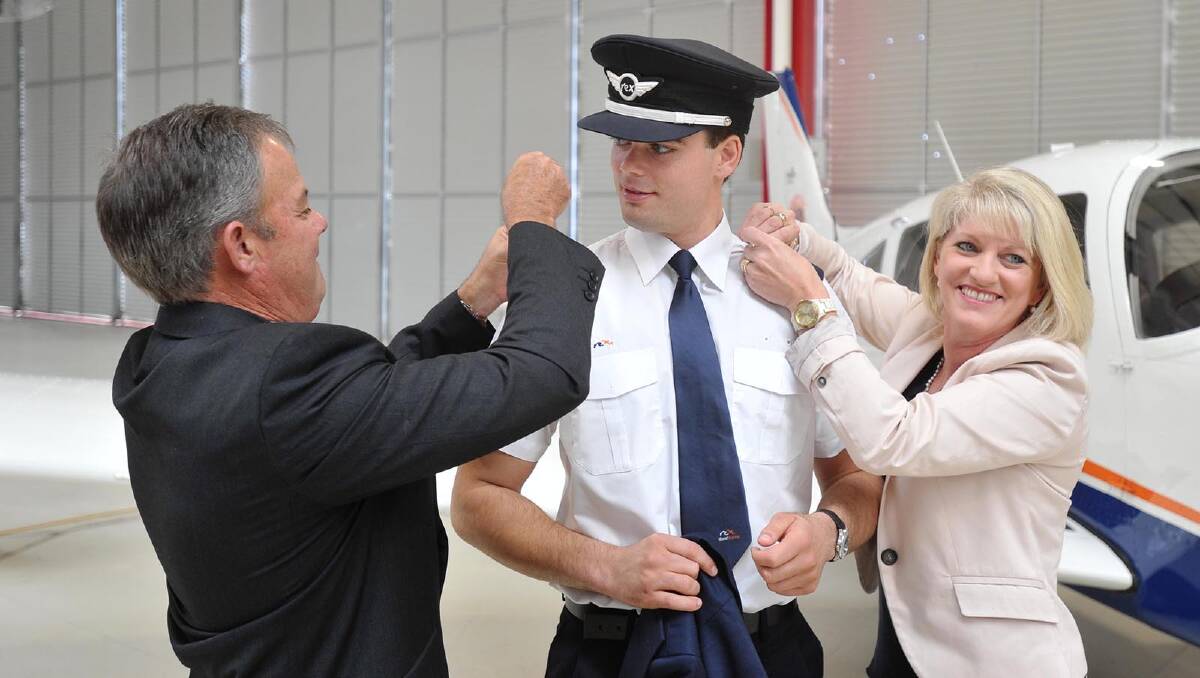 Alexander Preddey having his pilot's wings pinned on by father Mark and mother Virginia. Picture: Alastair Brook