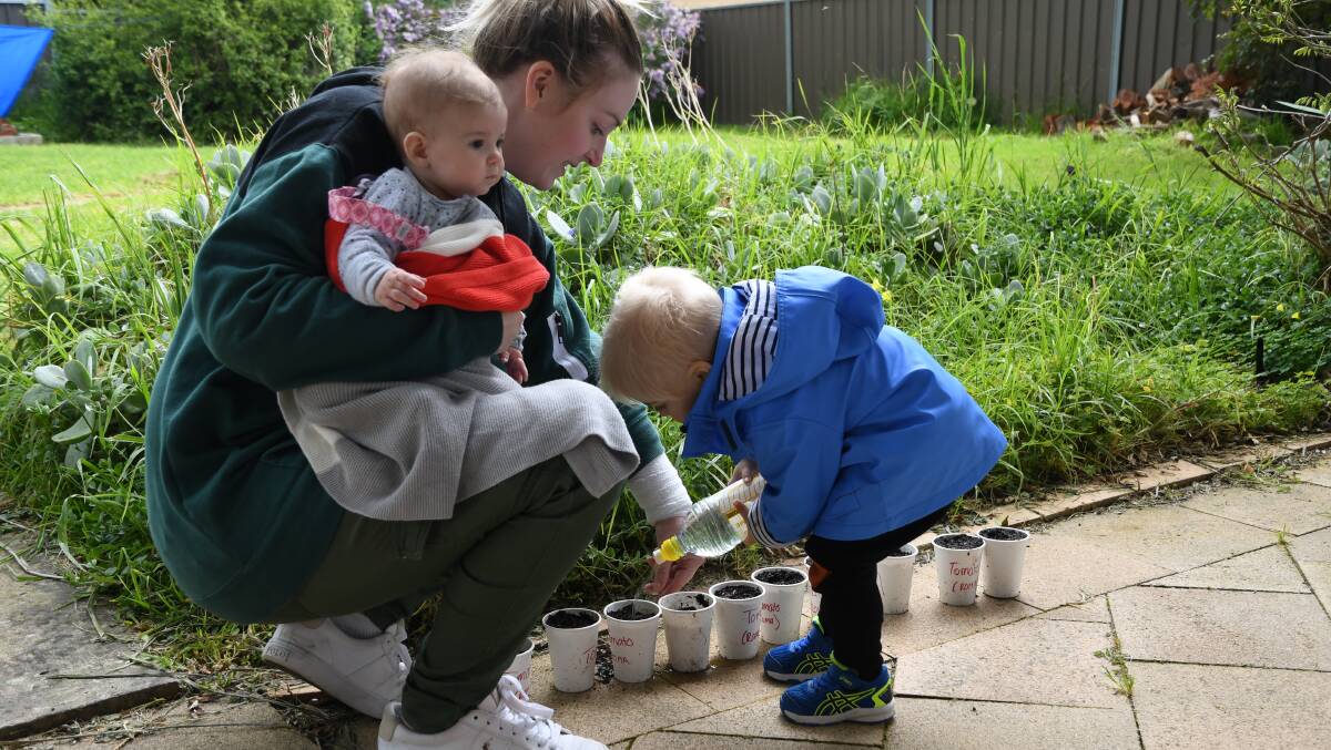 PLAY: Jenna Allen gardening with her two children Lilana (left) and Lorenzo in their backyard. Picture: ALEX DALZIEL