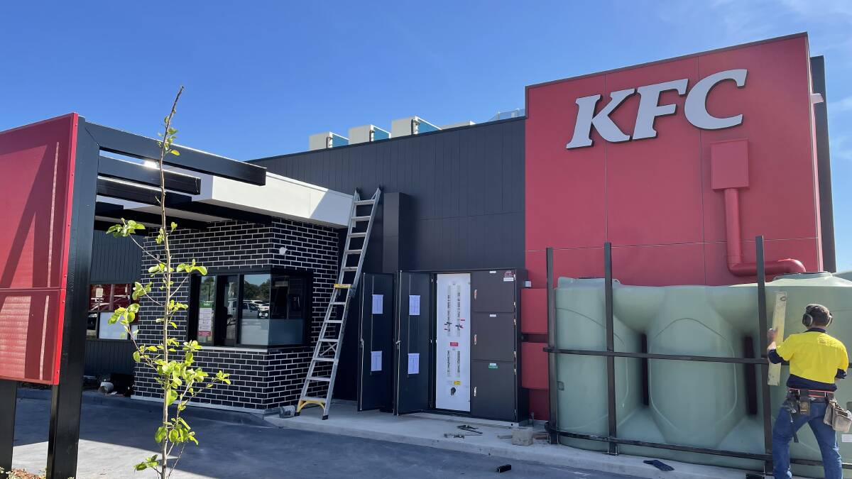 Workers put the final touches on the new KFC store opening in Glenfield on Monday. Picture: Penny Burfitt