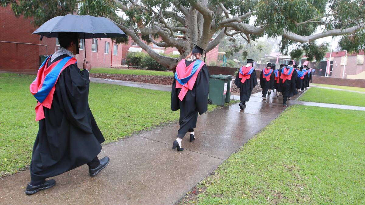 STAYING DRY: The rain didn't stop CSU graduates from celebrating the end of their degrees on Thursday morning. Picture: Les Smith