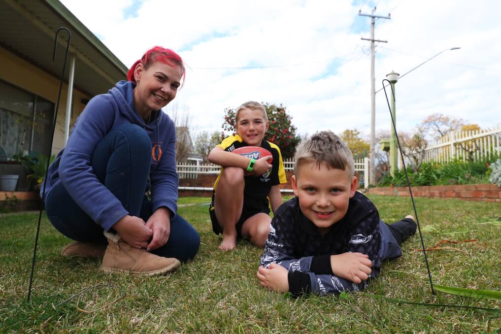 LOCKDOWN FUN: Single mother Alisha McIntyre is making the most of the snap seven-day lockdown with her two children Elijah, aged nine and Lachy, six, by spending time outdoors kicking the ball around. Picture: Emma Hillier