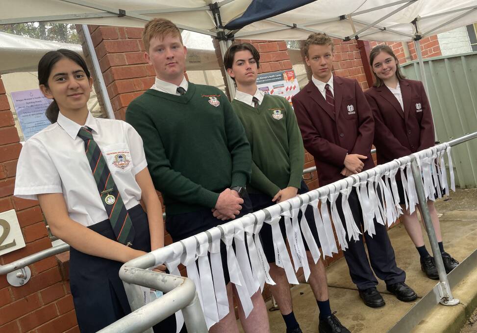 HONOURING: Wagga students Sarah Siddiqui, Paddy Malmo, Toby Humble, Daniel Goode and Indi McGill helped place ribbons to remember the Australian women lost to domestic violence this year. Picture: Emily Wind