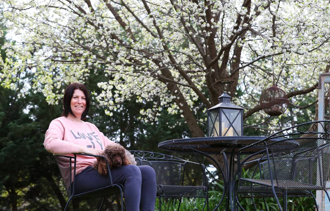 BLOSSOMING: Kim Breust and her dog Tilly enjoy some relaxation time in her garden at Springvale during lockdown. Picture: Emma Hillier