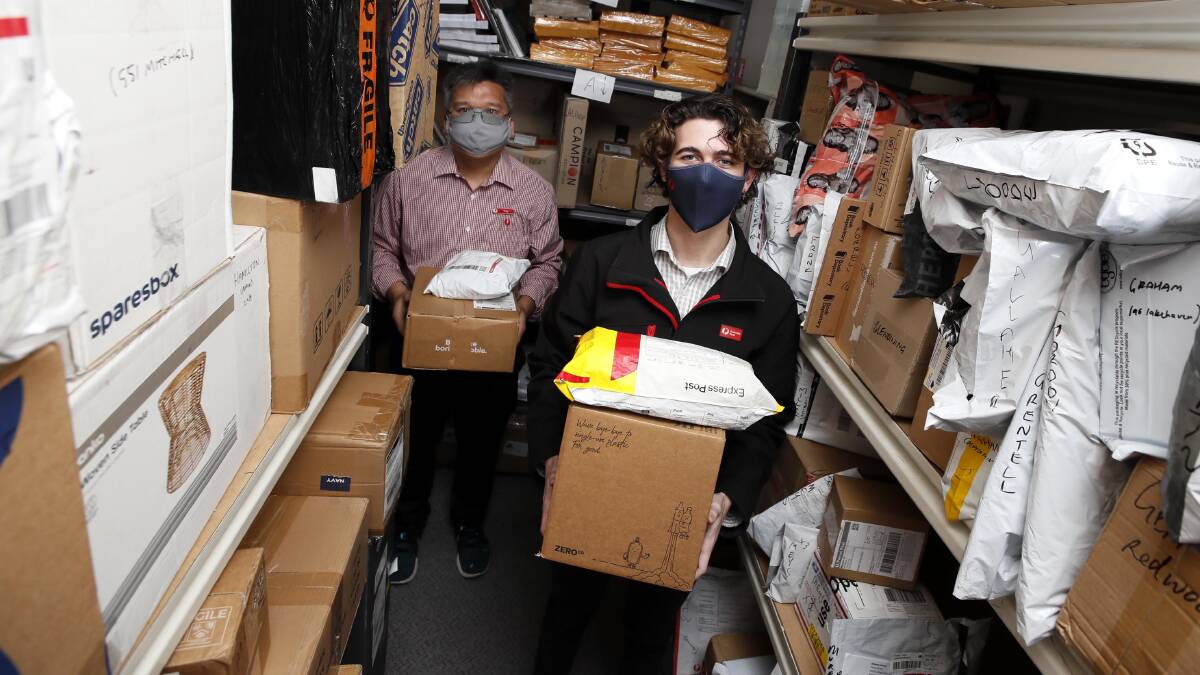 INCREASED DEMAND: Kooringal Post Office Licensee Troy Nguyen and employee Andrew Connor sort out parcels ready for delivery. Picture: Les Smith