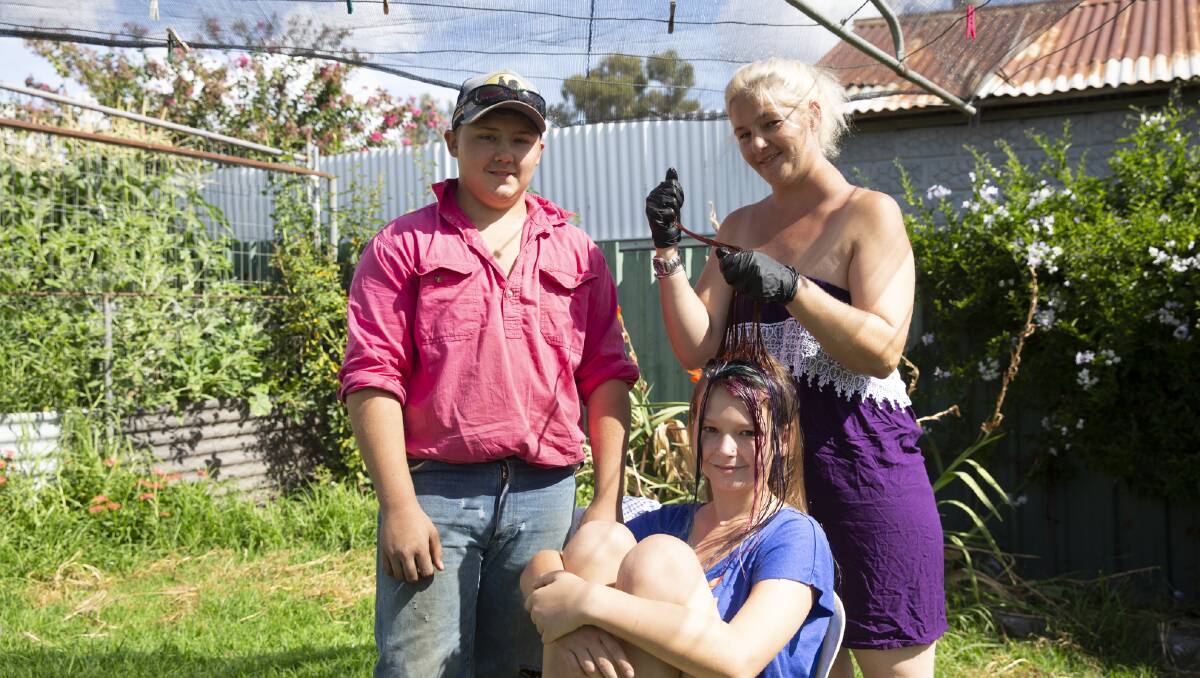 SUPPORTING OTHERS: Mel Meyers dyeing her daughter Caidence's hair, alongside son Beau at their Tarcutta home. Picture: Madeline Begley