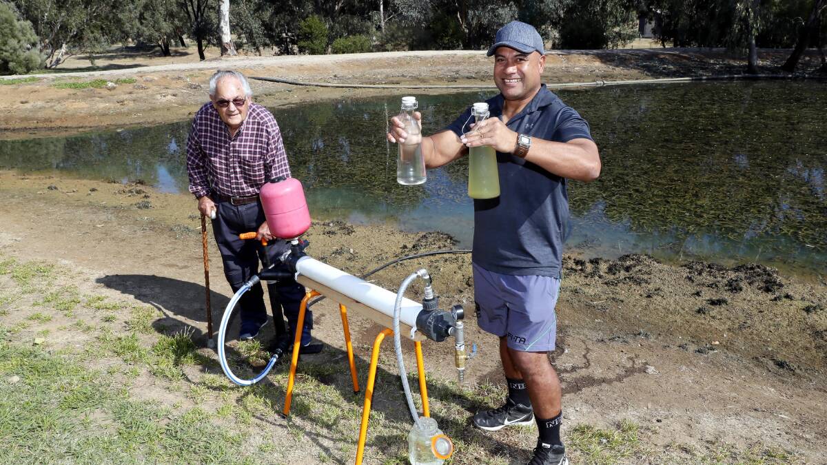 PROJECT WATER: Grange Lifestyle Village resident Howard Mendel and local Tongan man Sione Fekeila demonstrate the water filtration system before sending four of the mechanisms to Tonga. Picture: Les Smith