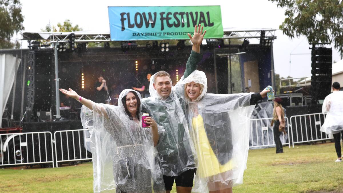 RAIN ON ME: Sandi Smart, Jake Finemore and Rachel Hogg from Wagga weren't afraid of the rain at this year's Flow Festival in Lake Albert. Picture: Les Smith.