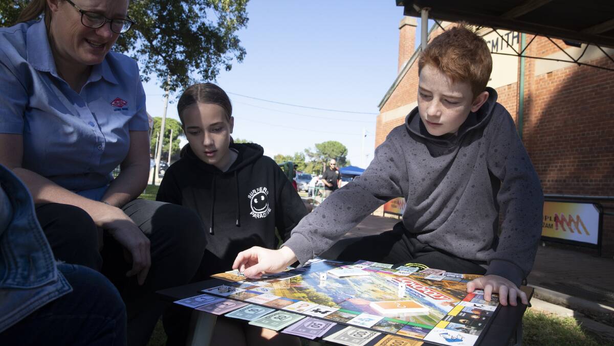 PLAYING TO WIN: Theresa Frankham tests out the Monopoly Wagga edition with her children Jasmine Bourne, 12, and Dylan Bourne, 10. Picture: Madeline Begley