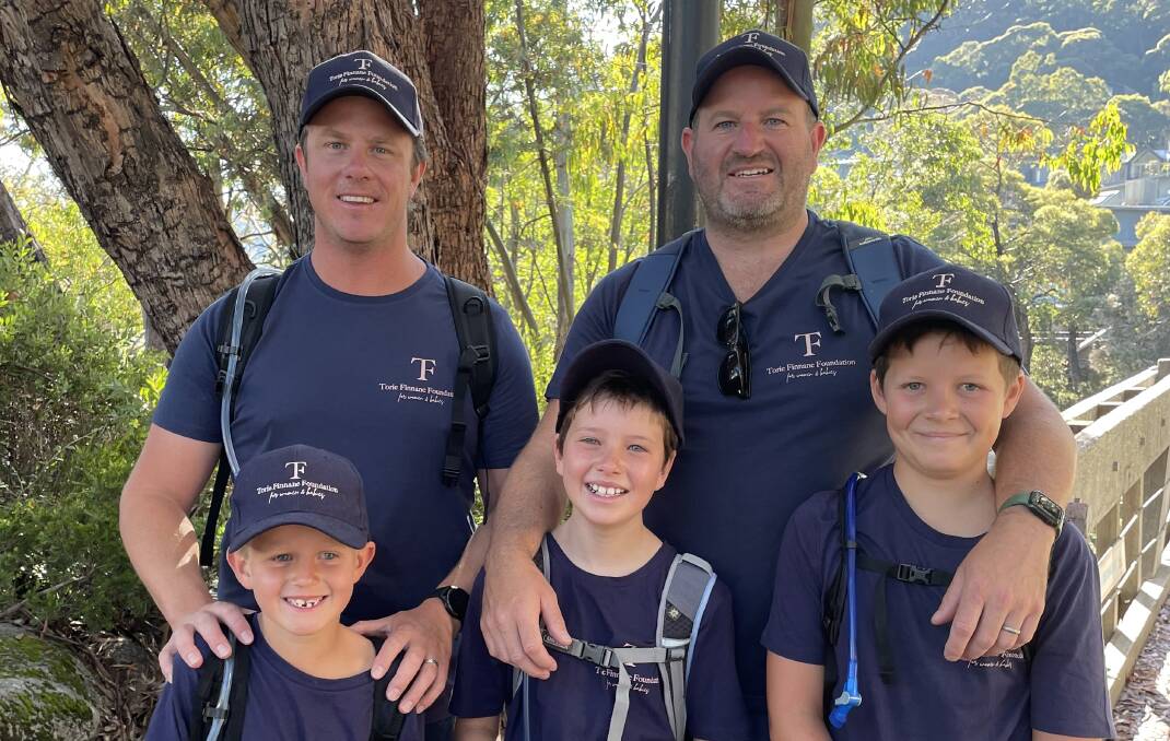 INSPIRING EFFORT: Ollie Finnane, 6, from Orange, Ted O'Hare, 8, from Wagga and Finn Gibson, 10, from Sydney supported by Dads Liam Finnane and Geoff O'Hare at the Mountain Kosciuszko summit walk on Australia Day. Photo: Courtesy, Genevieve O'Hare. 