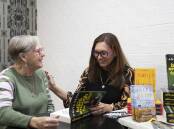 TEN YEARS ON: Wiradyuri woman and author Anita Heiss signs a copy of her book 'Am I Black Enough For You?' for Jan Roberts at the Curious Rabbit on Sunday. Picture: Madeline Begley