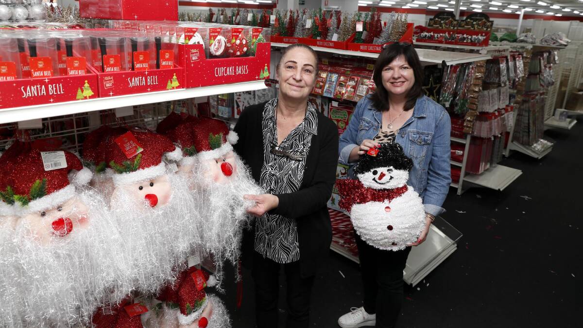 Silly Solly's store manager Linda Simmonds stacks the Christmas isle alongside store owner Lisa Toohey-Bott. Picture by Les Smith