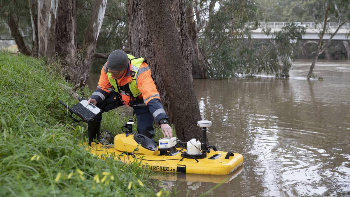 GOING WITH THE FLOW: Water NSW technicians work with a Surfbee Flowseeker to determine the depth and velocity of water. Picture: Madeline Begley