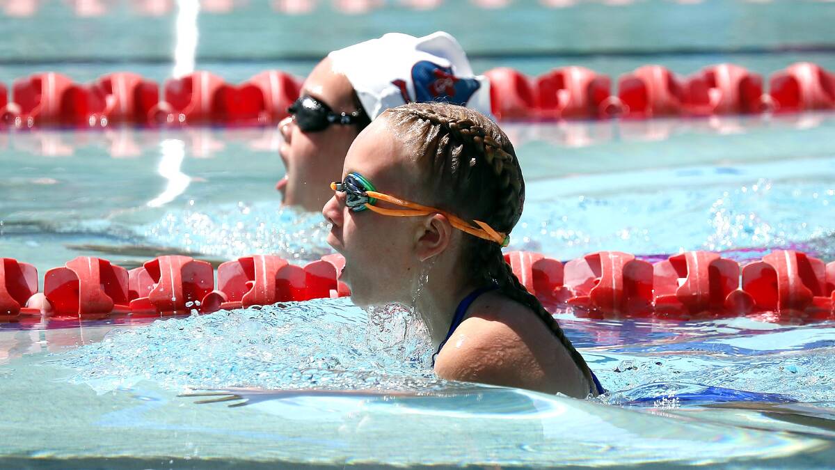 NECK AND NECK: Mater Dei's Indi Irvine (cap) and Henschke's Kealie Johnson stage a close finish in the 11 Years Girls 50m breaststroke at the Wagga City and Country Deanery swimming carnival. Picture: Les Smith