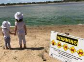 Signs warning the public about a blue-green algae bloom at Lake Albert in 2018.