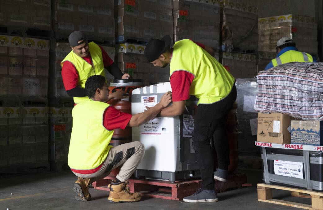 Villami Tautua'a, Alama Feiloaki and Liueli Fifita (left to right) packing goods at Ron Crouch transport depot that will be shipped home to Tonga. Picture: Madeline Begley 