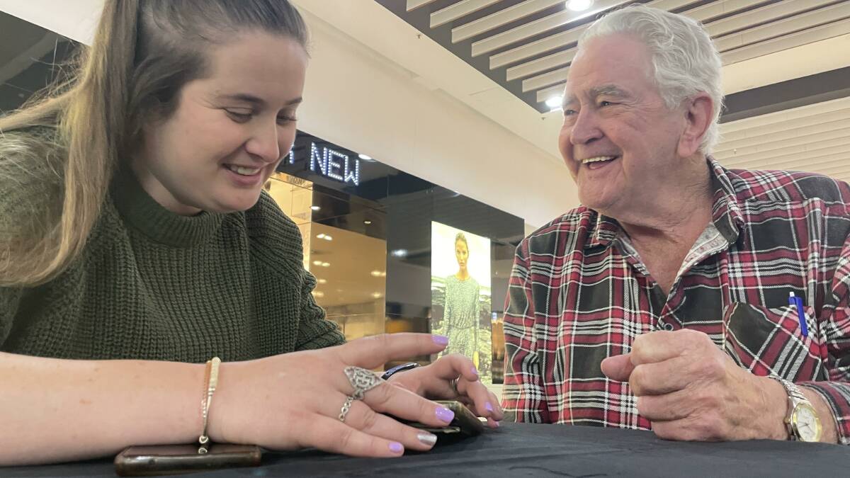 Breanna Taylor, 25, helping Vernon Pratt, 80, fix his phone's home screen configuration at today's first official tech help sessions at Wagga Marketplace. Picture: Tim Piccione 