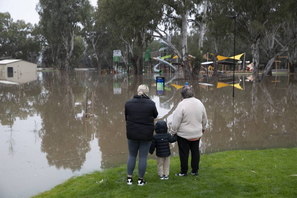 Kage Brenna, 3, with mother Maddi and grandmother Brenda checking out the floods at Wagga Beach just before 11am this morning. Picture: Madeline Begley