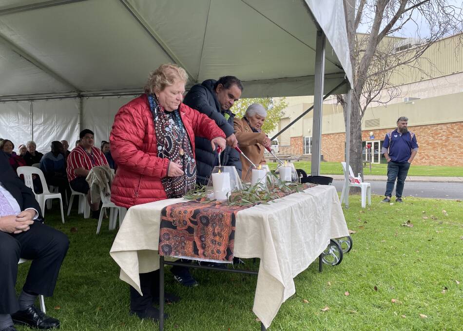 Wiradjuri elders (left to right) Aunty Kath Withers, Uncle James Ingram and Aunty Isabel Reid light candles to begin today's ceremony. Picture: Tim Piccione 