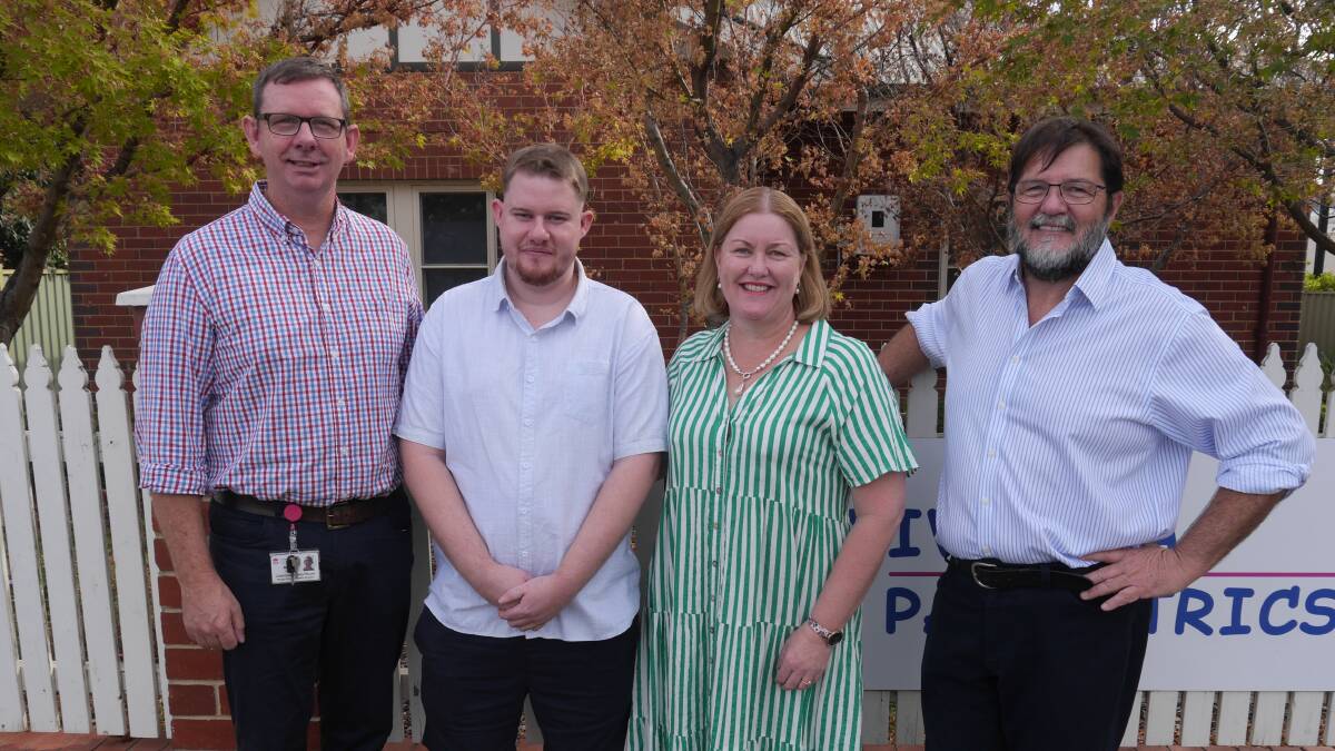 Mark Taylor with son Oliver, now 25, wife Cathrine and Wagga paediatrician John Preddy at Riverina Paediatrics where the donation was announced on Wednesday. Picture by Andrew Mangelsdorf