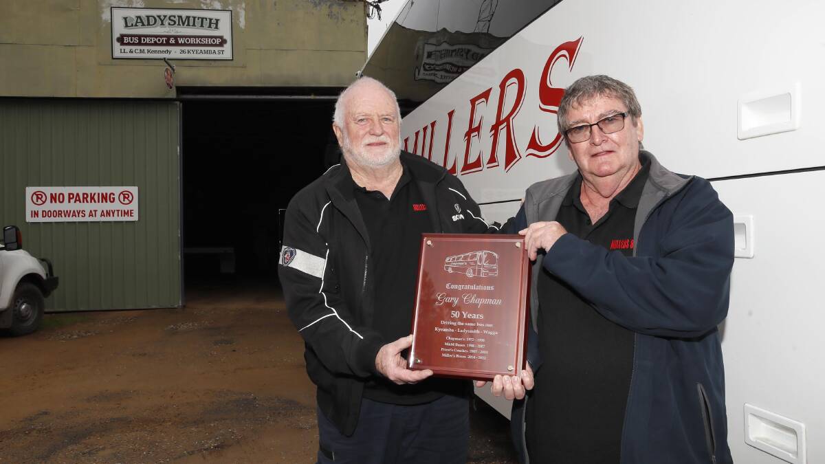 LIFETIME ACHIEVEMENT: Gary Chapman has just chalked up 50 years driving the same school bus route. He is pictured with boss Harry Miller at the Ladysmith depot on Wednesday. Picture: Les Smith
