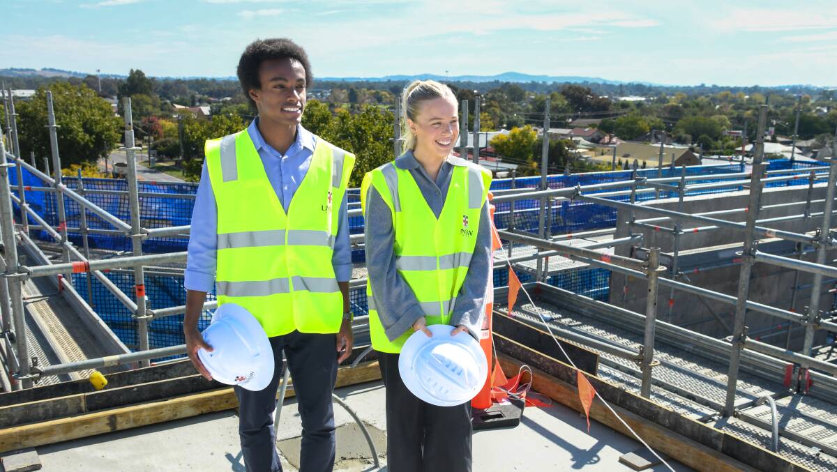 Wagga medical students Daniel Tilahun and Madeline Ingram on the roof of the new UNSW Biomedical Sciences Centre for the topping off ceremony on Monday. Picture by Bernard Humphreys