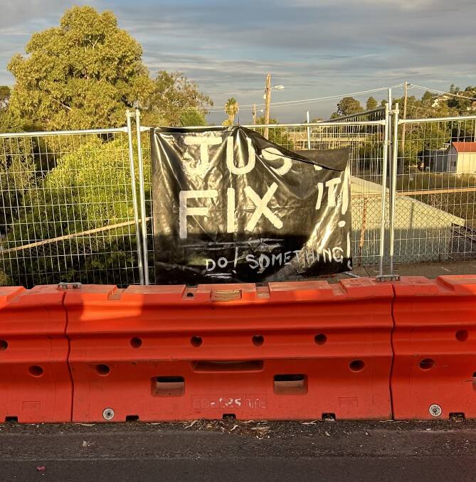 A sign calling for action on the damaged Edmonson Street Bridge was spotted adorning the safety barriers on Monday. Picture supplied