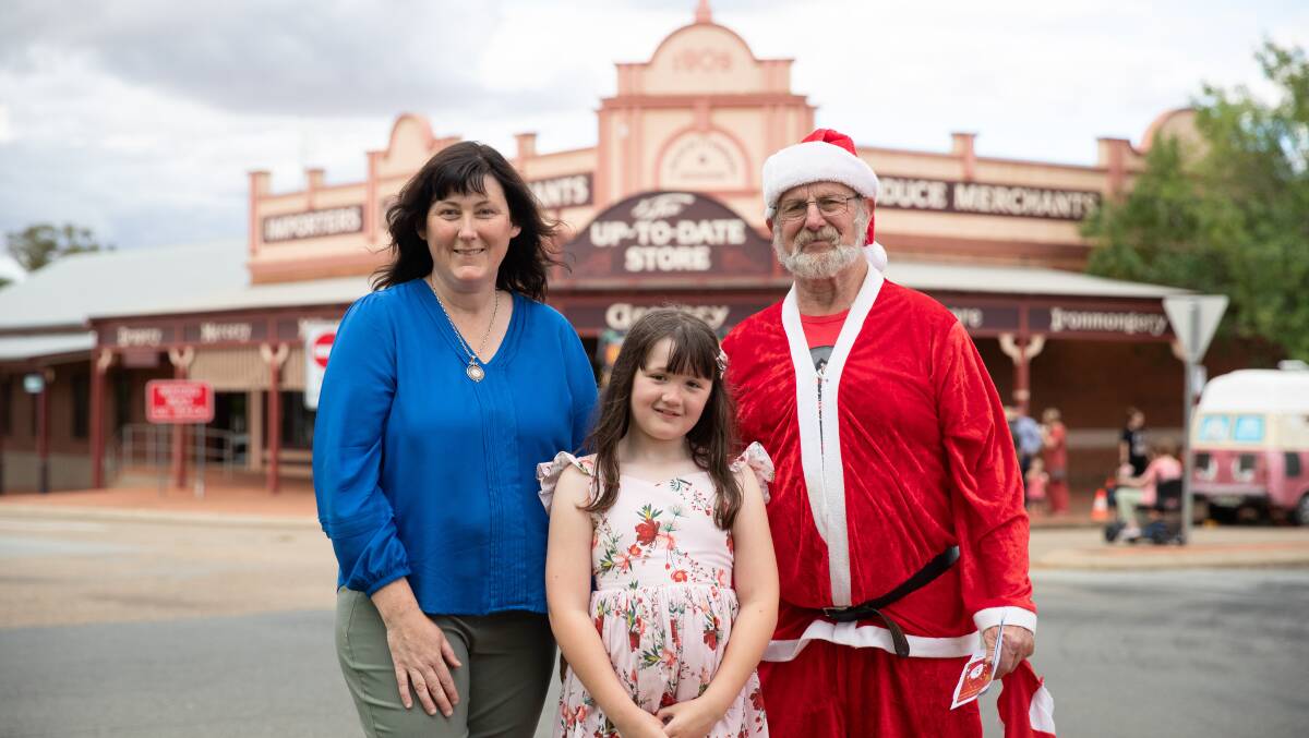 Event organiser and Coolamon post office owner Valerie McKelvie pictured with daughter Keira Crocker, 8, and postie Geoff MacQuarie as 'Christmas on Cowabbie' kicks off. Picture by Madeline Begley