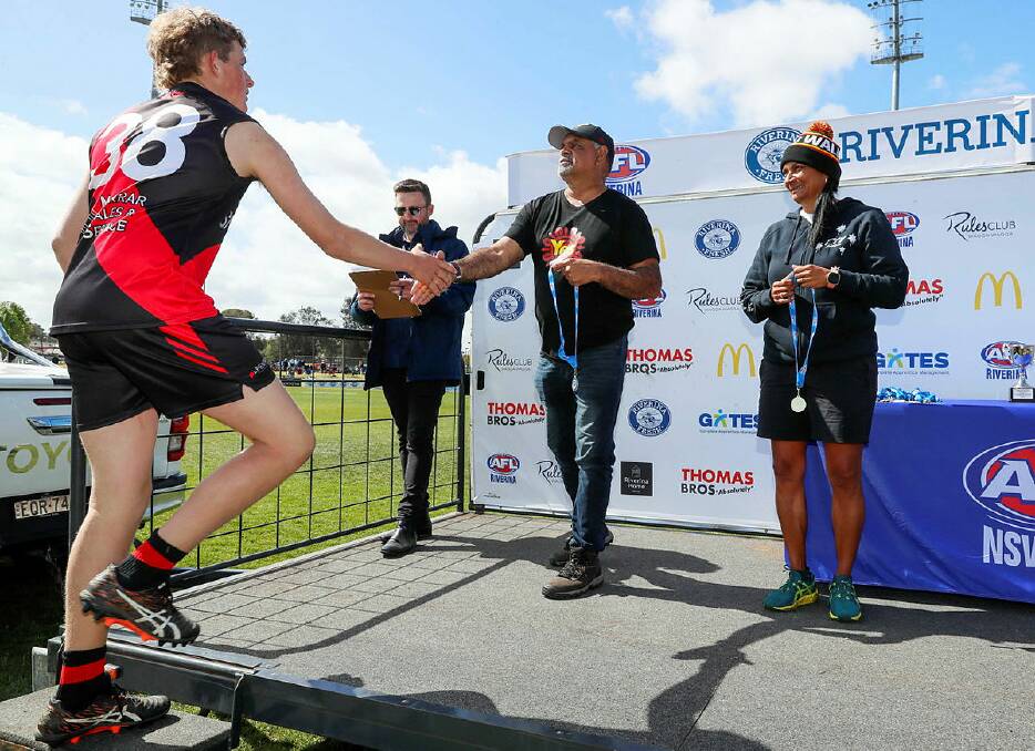 Michael Long (centre) and Nova Peris (right) present Marrar Bomber Charlie Davey Marrar with a medal following their victory against North Wagga in the under 17 Farrer League Grand Final at the weekend. Picture by Les Smith