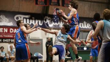 AIRTIME: Wagga Heat's Angus Lourey grabs the ball above Central Coast Waves' Jordan Gregory. Picture: Madeline Begley
