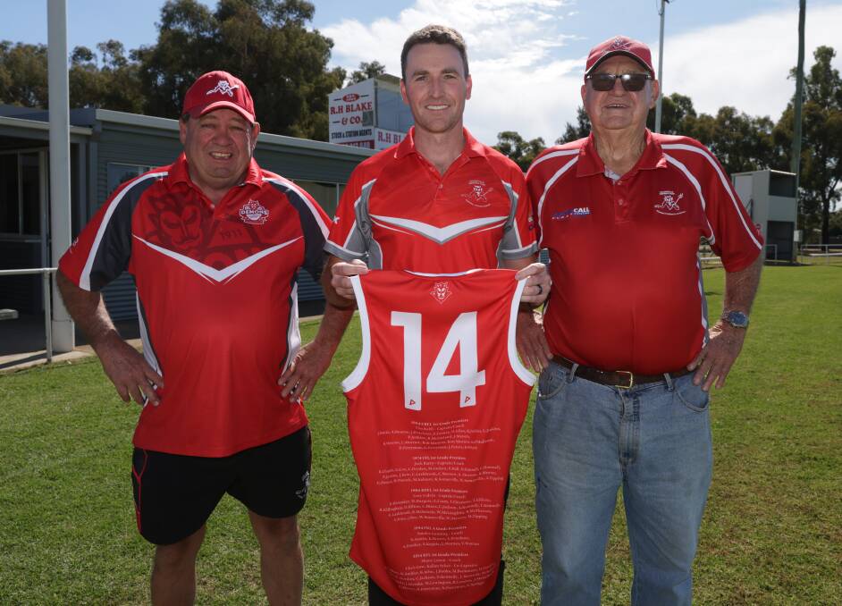 Collingullie-Wagga president Noel Penfold, 2014 premiership co-captain Kal Sykes and 1964 and 1974 premiership player Ken Morrow showcase the special guernsey the Demons will wear on Saturday. Picture by Tom Dennis