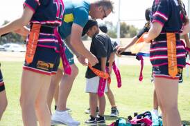 Former NRL and rugby union player Mark Gasnier introduces children including Griffith's Austin Cook, 6, to the game he has created, tri tag rugby, in a session at Parramore Park. Picture by Madeline Begley