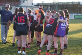 Wagga Swans players are addressed by their coach at Bolton Park last year. 
